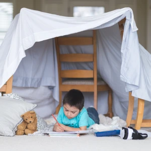 Child playing in a fort tent